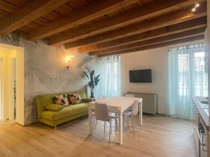 CAIROLI14 في بريشيا: غرفة معيشة مع أريكة خضراء وطاولة