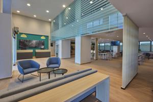 an office lobby with two chairs and a table at City Express by Marriott Cancun Aeropuerto in Cancún