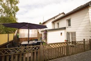 a table with an umbrella on a fence at Carmius - Back to simple life in Burg-Reuland