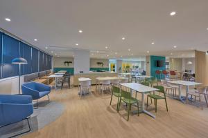 a cafeteria with tables and chairs and a counter at City Express by Marriott Cancun Aeropuerto in Cancún