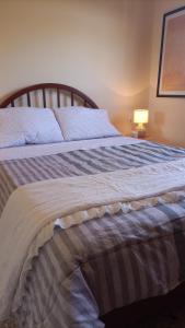 ein Schlafzimmer mit einem Bett mit einer gestreiften Decke in der Unterkunft Moka's house 