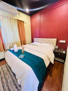 a bedroom with two beds and a red wall at Jhelum Villa by Sharayu Holidays in Panchgani