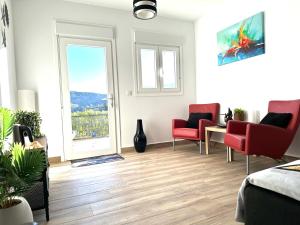 a living room with red chairs and a window at B&B Villa Archez in Árchez