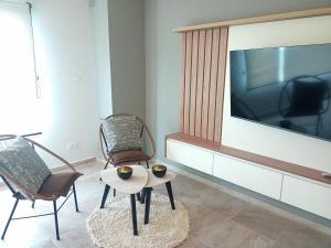 Una sala de estar con dos sillas y un televisor de pantalla plana. en MONTE HERMOSO 1DORM CENTRO, en Monte Hermoso
