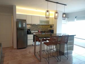 Una cocina con mesa y sillas y un refrigerador. en MONTE HERMOSO 1DORM CENTRO, en Monte Hermoso