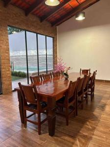 uma sala de jantar com uma mesa de madeira e cadeiras em Casa Sa Pedra em Aparecida de Goiânia