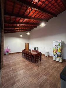 a dining room with a table and a refrigerator at Casa Sa Pedra in Aparecida de Goiânia
