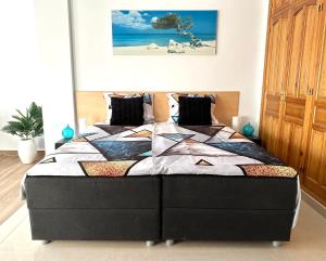 a bedroom with a black bed with a colorful quilt at B&B Villa Archez in Árchez