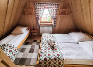 2 camas individuales en una habitación con ventana en Domek góralski en Ciche Małe