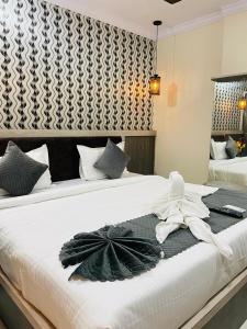 a bedroom with two beds with white towels on them at Hotel Blue Petals in Shamshabad