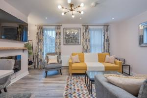 a living room with a yellow couch and chairs at Belfast City Centre - 3 bed, 3 bathroom & parking by StayByNumbers in Belfast