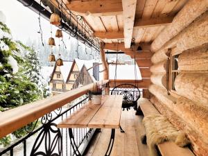 d'un balcon avec un banc en bois et une table. dans l'établissement Domek góralski, à Małe Ciche