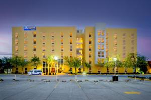 un gran edificio con un estacionamiento delante de él en City Express by Marriott Silao Aeropuerto, en Silao