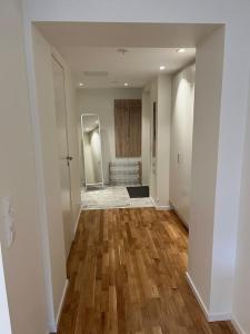 een lege hal met houten vloeren in een huis bij New apartment, perfect for exploring Stockholm in Lidingö