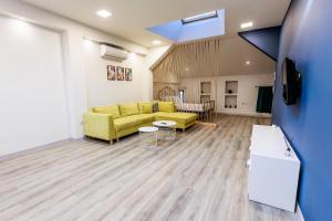 een woonkamer met een gele bank in een kamer bij B3 Delux Studio Saffron in Plovdiv