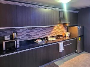 uma cozinha com um frigorífico e um micro-ondas em Kandi Modern 1BR, king bed. Wi-Fi, housekeeping! em Angeles