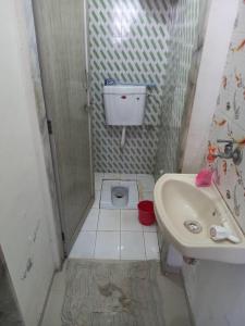 a small bathroom with a sink and a toilet at Om Sai Guest House in Nashik