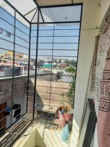 a balcony with glass windows and a view of a city at Om Sai Guest House in Nashik