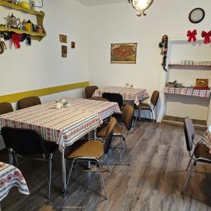 jadalnia z 2 stołami i krzesłami w obiekcie Guesthouse Casa Baciu w Sybinie