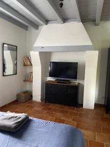 a room with a flat screen tv and a bed at gite " ploum" in Pouydesseaux