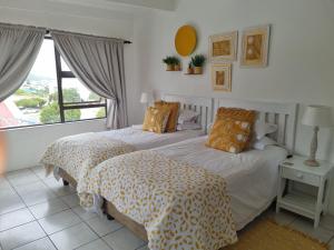 a bedroom with two beds and a large window at South Of Africa in Agulhas