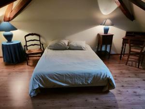 1 dormitorio con 1 cama grande y 1 silla en La Maillardière - Maison de campagne avec piscine, en Corné