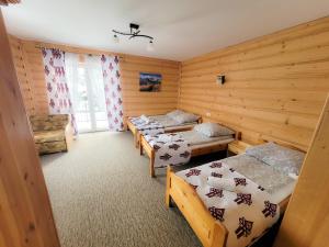 a room with three beds in a wooden room at Pokoje Gosinne U Ani i Andrzeja in Małe Ciche