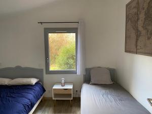 two beds in a room with a window at gite " ploum" in Pouydesseaux