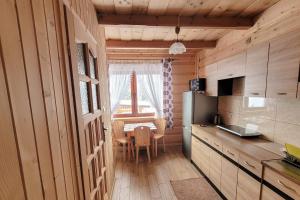 a small kitchen with a table and a window at Pokoje Gosinne U Ani i Andrzeja in Małe Ciche