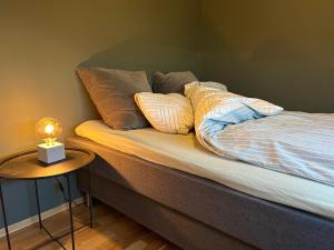 a bed with pillows on it with a side table at Pellestova Apartments in Hafjell