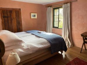 a bedroom with a bed with a blue blanket on it at The Barn, Higher Boden, Manaccan, Helston, Cornwall in Helston