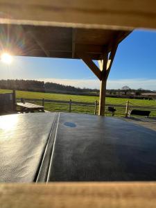 a view from the inside of a covered porch with a view of a field at Dukeries Retreat in Retford