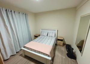 niewielka sypialnia z łóżkiem i oknem w obiekcie Apartamento Florianópolis w mieście Florianópolis