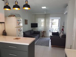 a kitchen and living room with a couch and a refrigerator at Bahçeli çift katlı villa sahile 300 metre in Kusadası