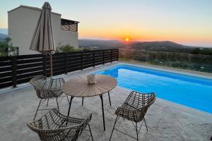 un patio con mesa y sillas junto a una piscina en Enjoy Romance and Sunsets at Villa Dionysos, en episkopi-heraklion