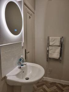 a white bathroom with a sink and a mirror at Hidden Gem. 1800s Bank Office. Knaresborough Town in Knaresborough