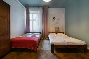 2 Betten in einem Zimmer mit Fenster in der Unterkunft Cozy Apartments Krakowska Street, Kazimierz District in Krakau