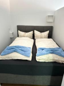 a bed with two blankets and two pillows at Hochwertige City & Messewohnung in Hannover