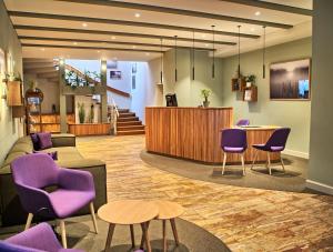 シュヴェリーンにあるSeehotel Frankenhorst - BW Signature Collectionの紫色の椅子と待合室のあるロビー