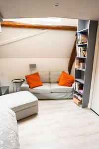 a living room with a couch with orange pillows at De Kapelle in Oudewater in Oudewater