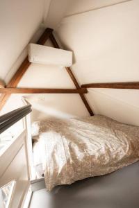 a small room with a bed and a lamp at De Kapelle in Oudewater in Oudewater