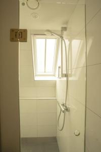La salle de bains est pourvue d'une douche et d'une fenêtre. dans l'établissement De Kapelle in Oudewater, à Oudewater