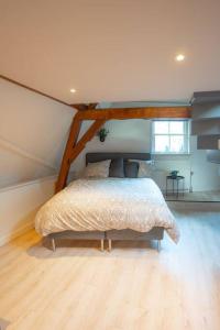 OudewaterにあるDe Kapelle in Oudewaterのベッドルーム1室(屋根裏部屋に大型ベッド1台付)