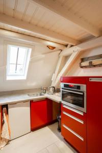 a kitchen with red cabinets and a red oven at De Kapelle in Oudewater in Oudewater