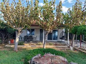 a house with trees in front of a yard at Fairytale στις Αλυκές Χαλκίδας in Chalkida