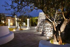 a courtyard with a tree and a stone wall at Tenuta Serre in Salve