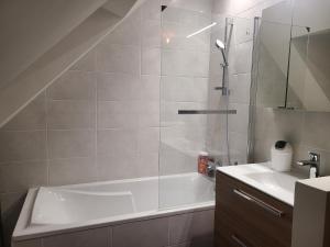 a bathroom with a shower and a tub and a sink at Maison cozy - Proche de la Cale de Taden in Taden