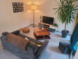 a living room with a couch and a coffee table at Maison cozy - Proche de la Cale de Taden in Taden
