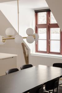 a table and chairs in a room with a window at Central City Flats on Best Location by Round Tower in Copenhagen