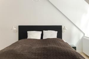 a bedroom with a large bed with two pillows at Central City Flats on Best Location by Round Tower in Copenhagen